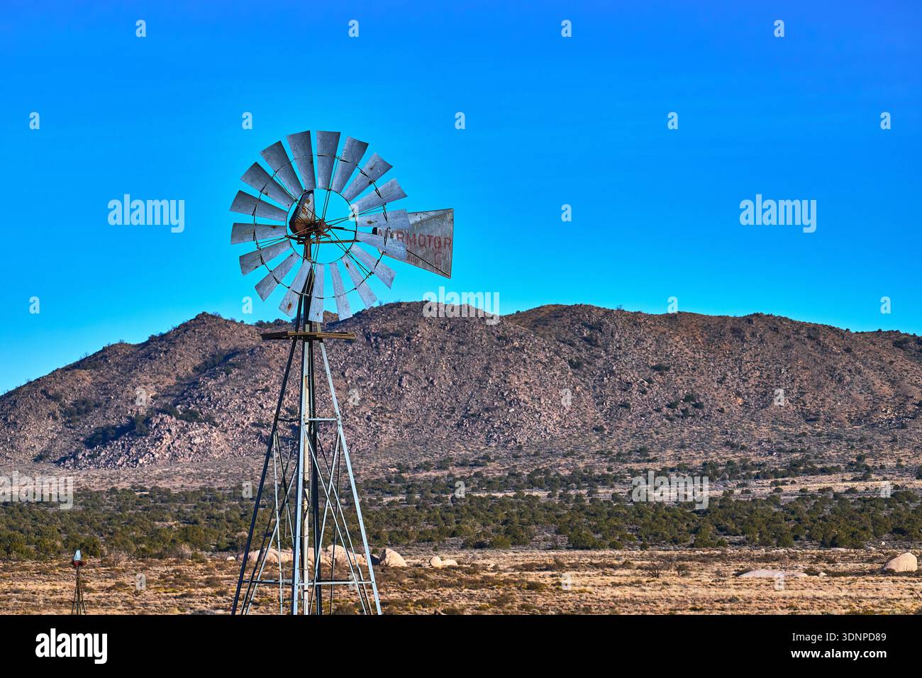 Moulin à vent et Rocky Hills sous Clear Blue Sky dans le désert californien de Mojave Banque D'Images