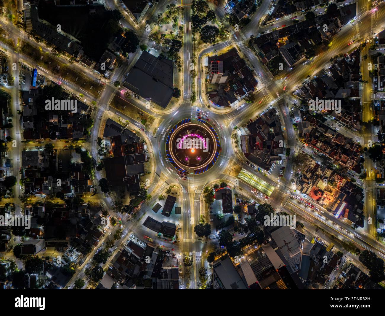 Longue exposition aérienne du rond-point la Minerva de Guadalajara la nuit, montrant la circulation dynamique, la fontaine illuminée et la ligne d'horizon moderne. Banque D'Images