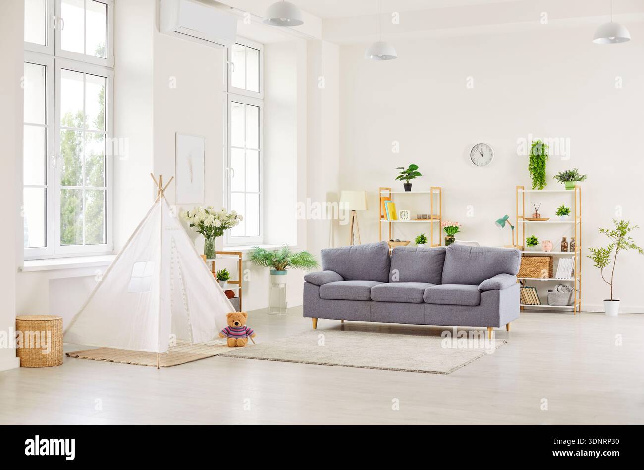 Un intérieur confortable de salon moderne avec un canapé gris et une tente de tipi pour enfants Banque D'Images