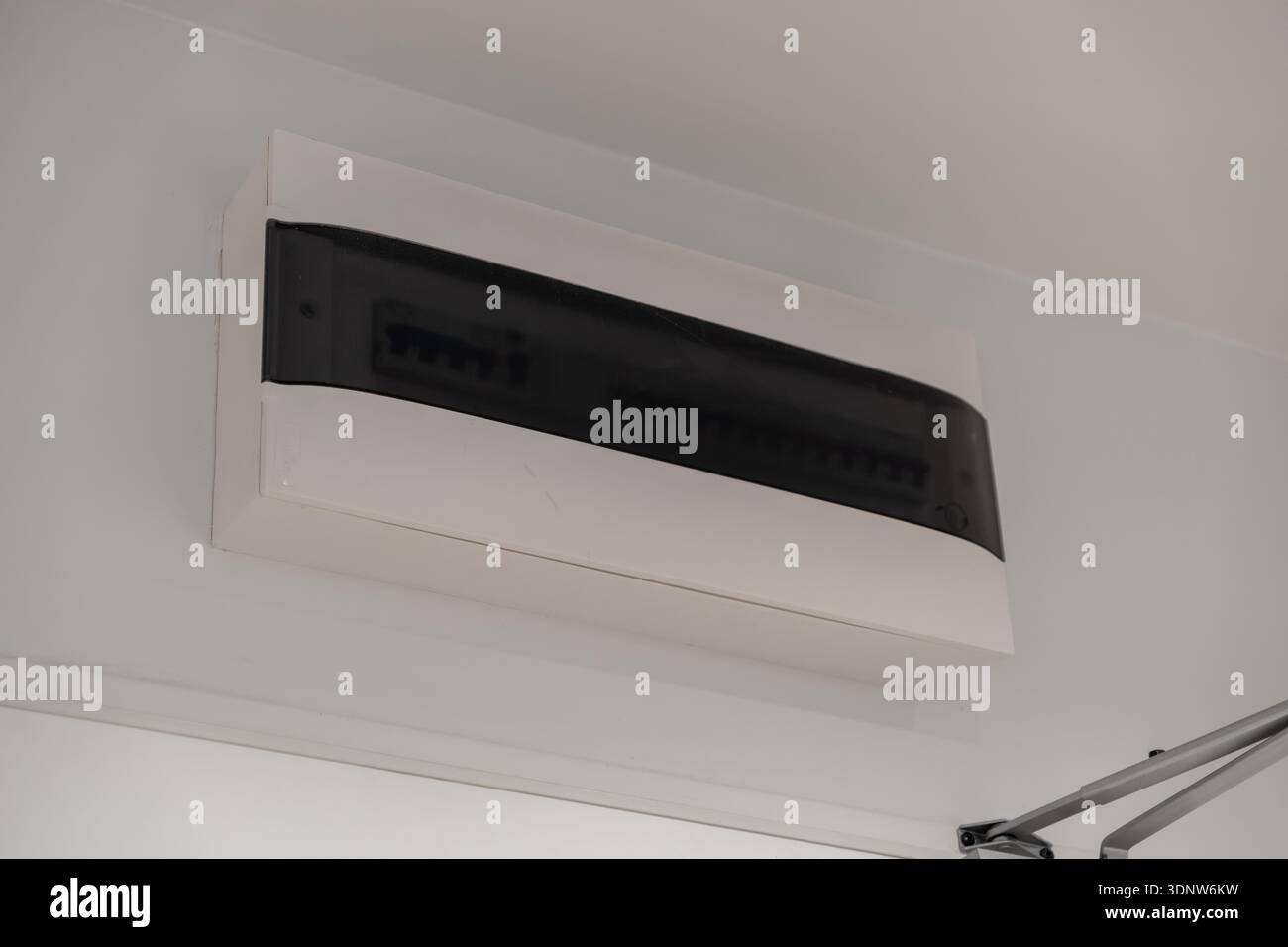 Vue détaillée d'une boîte à fusibles électrique contemporaine avec un couvercle translucide foncé, représentant une gestion fiable de l'alimentation domestique et un électr crucial Banque D'Images