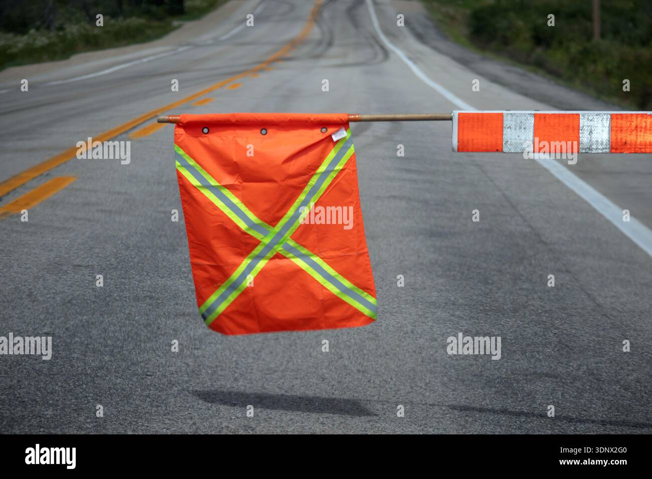 Barrière temporaire de fermeture de route avec drapeau orange réfléchissant au Canada Banque D'Images