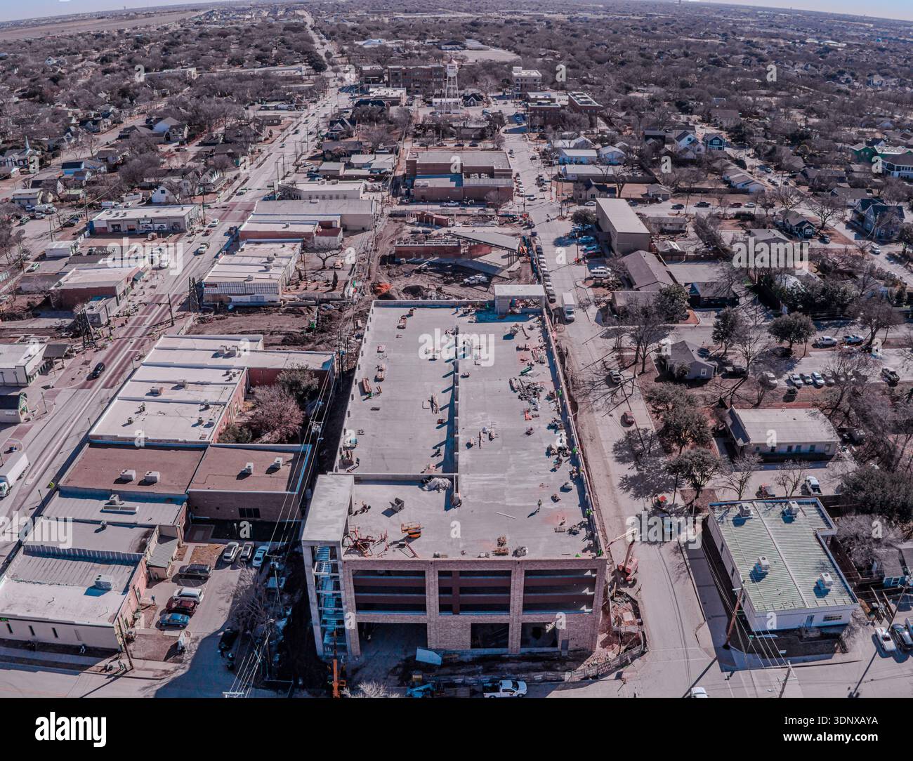 Vue aérienne de bâtiments baignés de soleil projetant de longues ombres le long des rues de la ville, mélangeant textures urbaines et éléments naturels, Frisco, Texas, United Banque D'Images