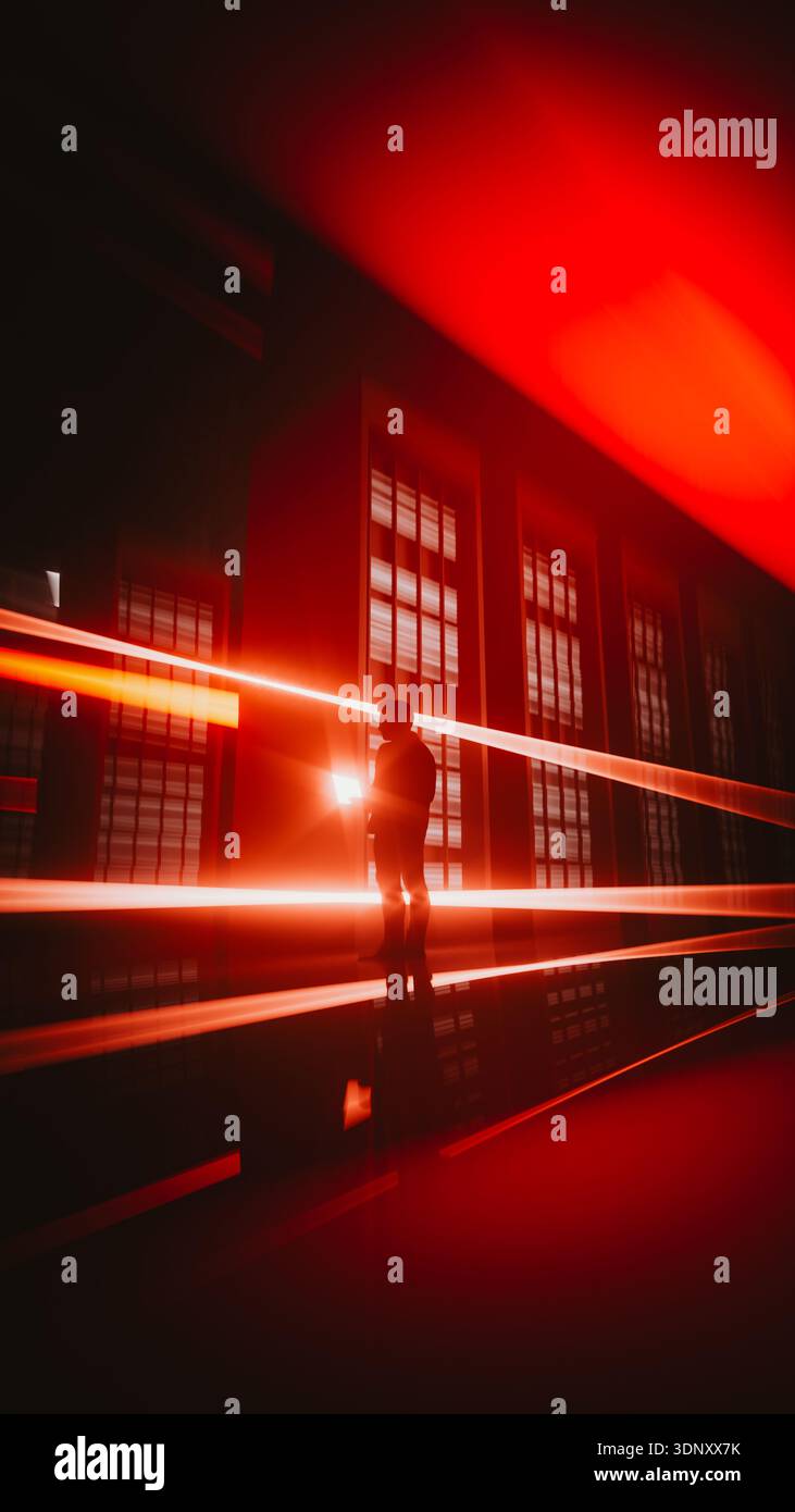 Un technicien est engagé avec un ordinateur portable dans un centre de données de pointe. Les lumières vives créent une atmosphère dynamique remplie de technologie. Banque D'Images