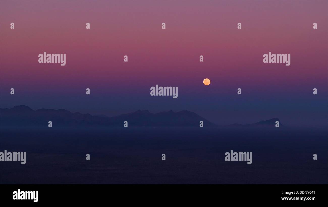 Vue aérienne de la lune brillante doucement sur les montagnes silhouettées contre un ciel dégradé, une vue sereine du crépuscule, Cape Town, Western Cape, South A Banque D'Images