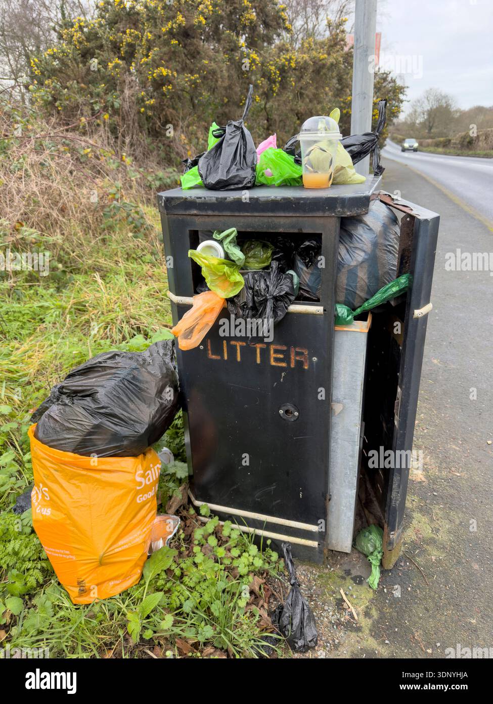 WIRRAL, MERSEYSIDE, ANGLETERRE - 30 DÉCEMBRE 2025 : poubelle de rue débordant de sacs en plastique et de déchets en Angleterre. Banque D'Images