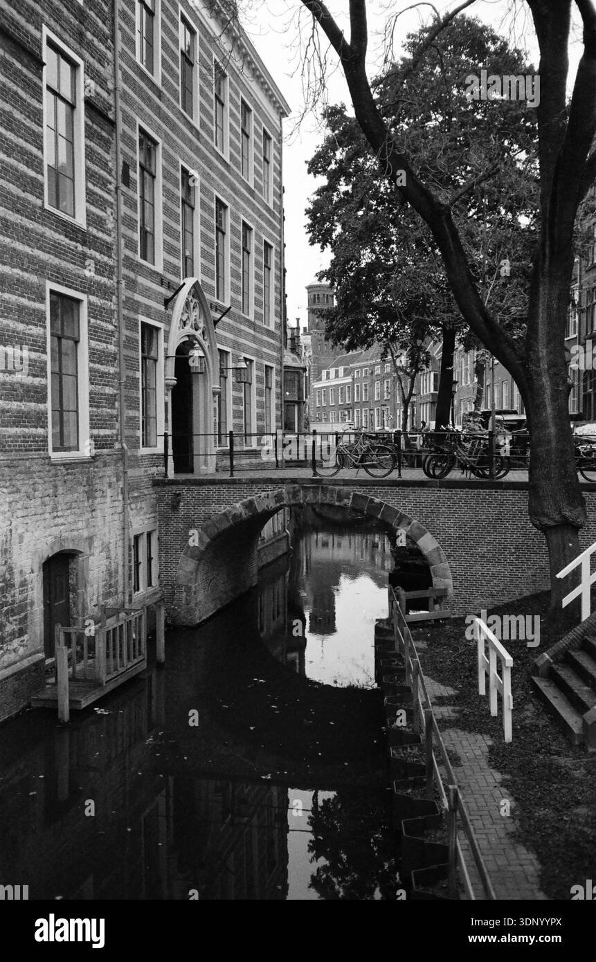 canal avec pont près de la maison avec vélos et arbres sur film noir et blanc 35 mm Banque D'Images