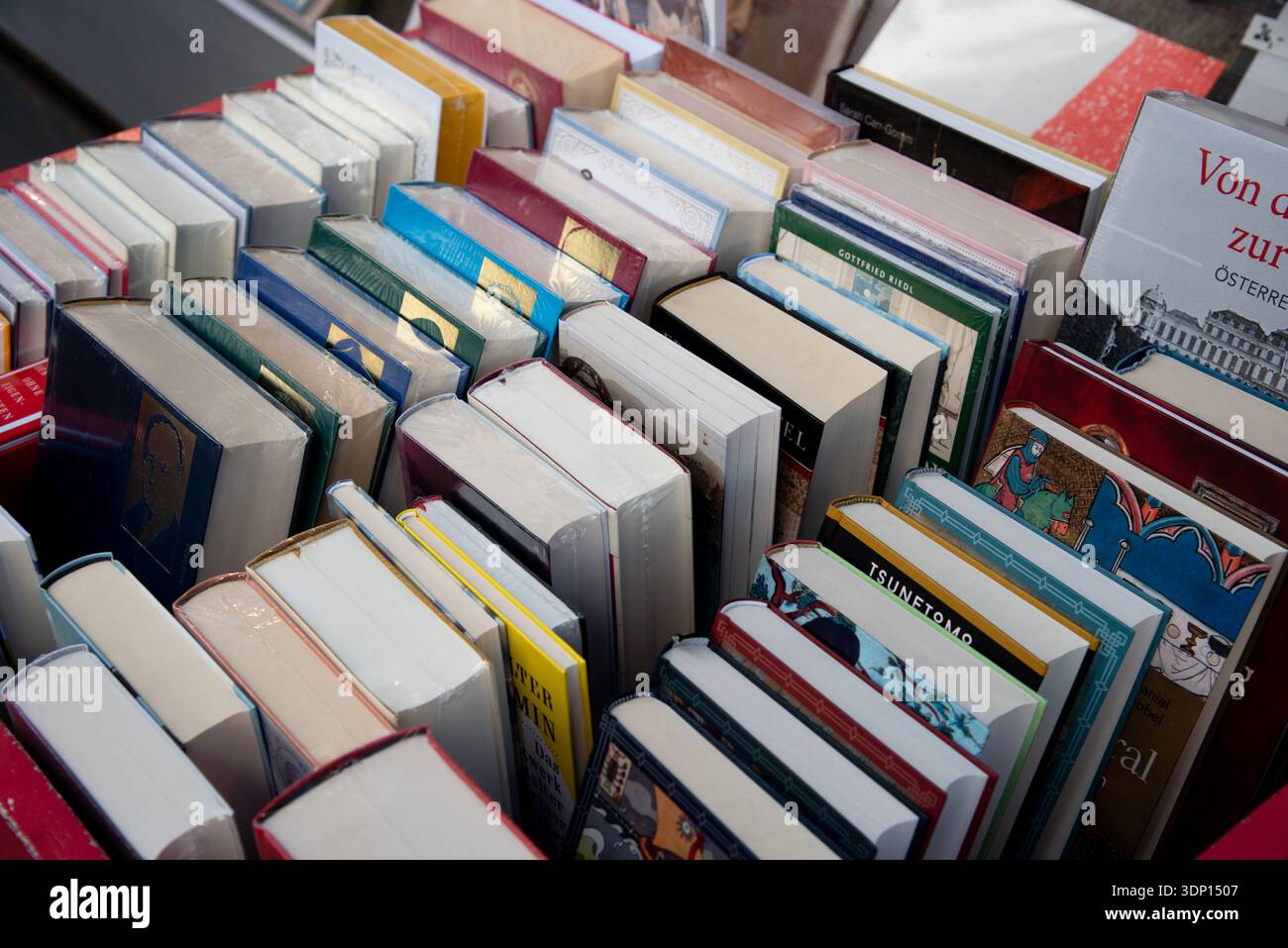 Livres densément emballés sur des étagères, avec diverses épines et reliures colorées, symbolisant l'éducation, la connaissance Banque D'Images