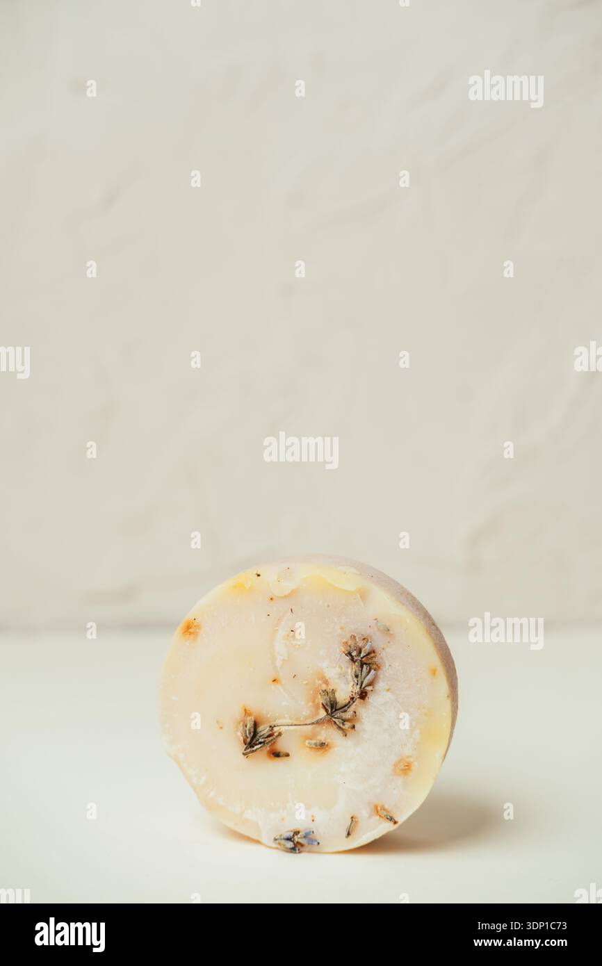 Savon à la lavande crémeux fait à la main intégré avec des pétales de fleurs séchées et un éclairage doux Banque D'Images