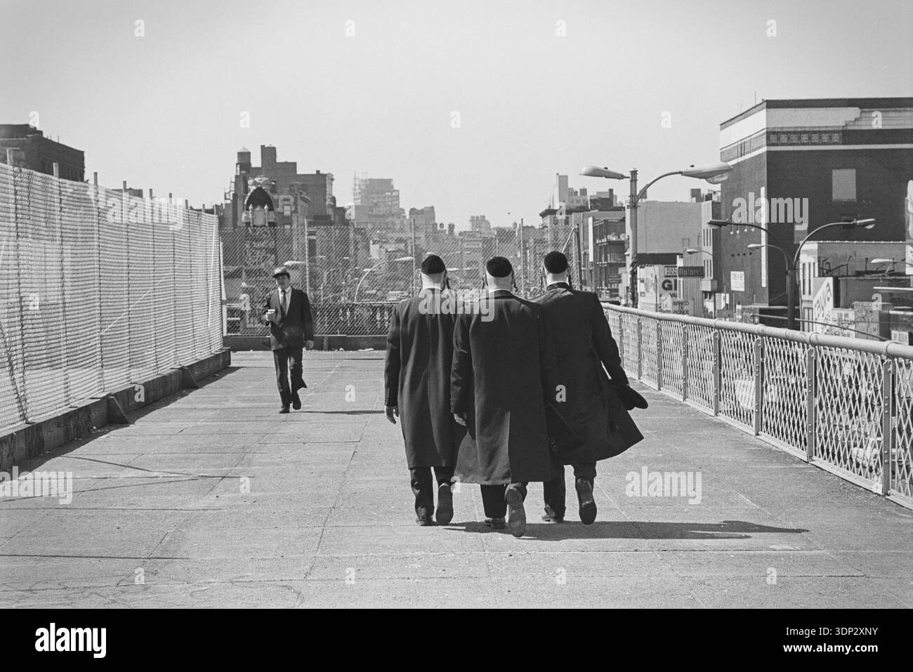 Groupe d'hommes juifs hassidiques marchant à travers le sentier piétonnier du pont de Williamsburg, New York, avril 1991. Banque D'Images