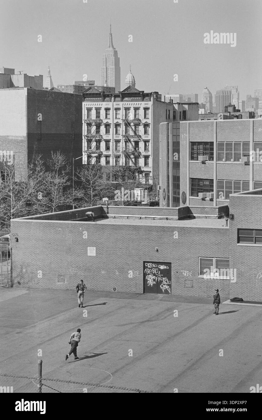 Vue surélevée d'un terrain de jeu dans le Lower East Side avec l'Empire State Building à l'horizon, New York City, avril 1991. Banque D'Images