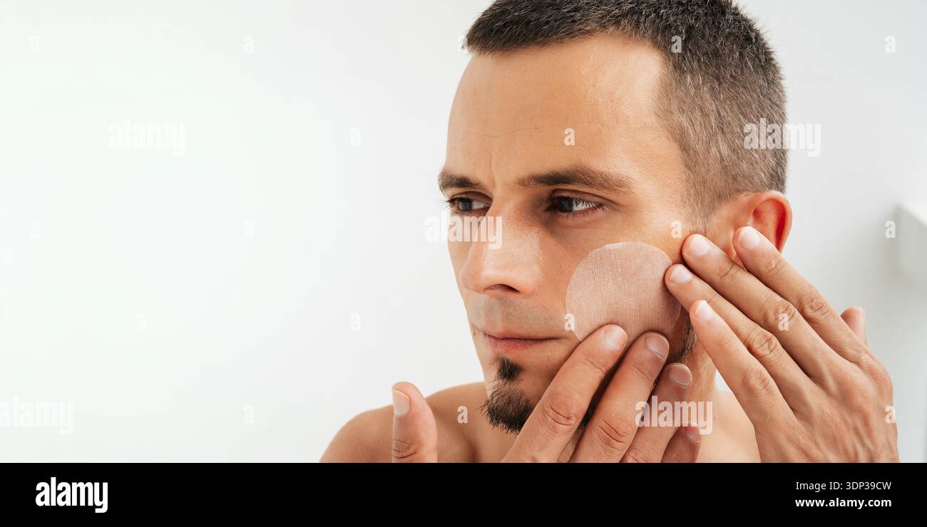 Un visage d'homme avec un tampon hydratant. Copie de l'espace Banque D'Images