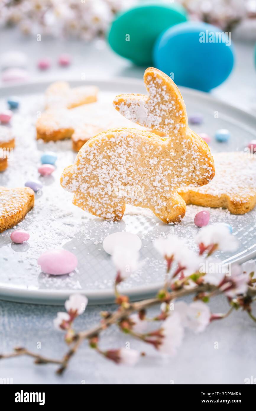 Biscuits aux amandes de lapin de Pâques et œufs de Pâques sur une table de fête décorée Banque D'Images