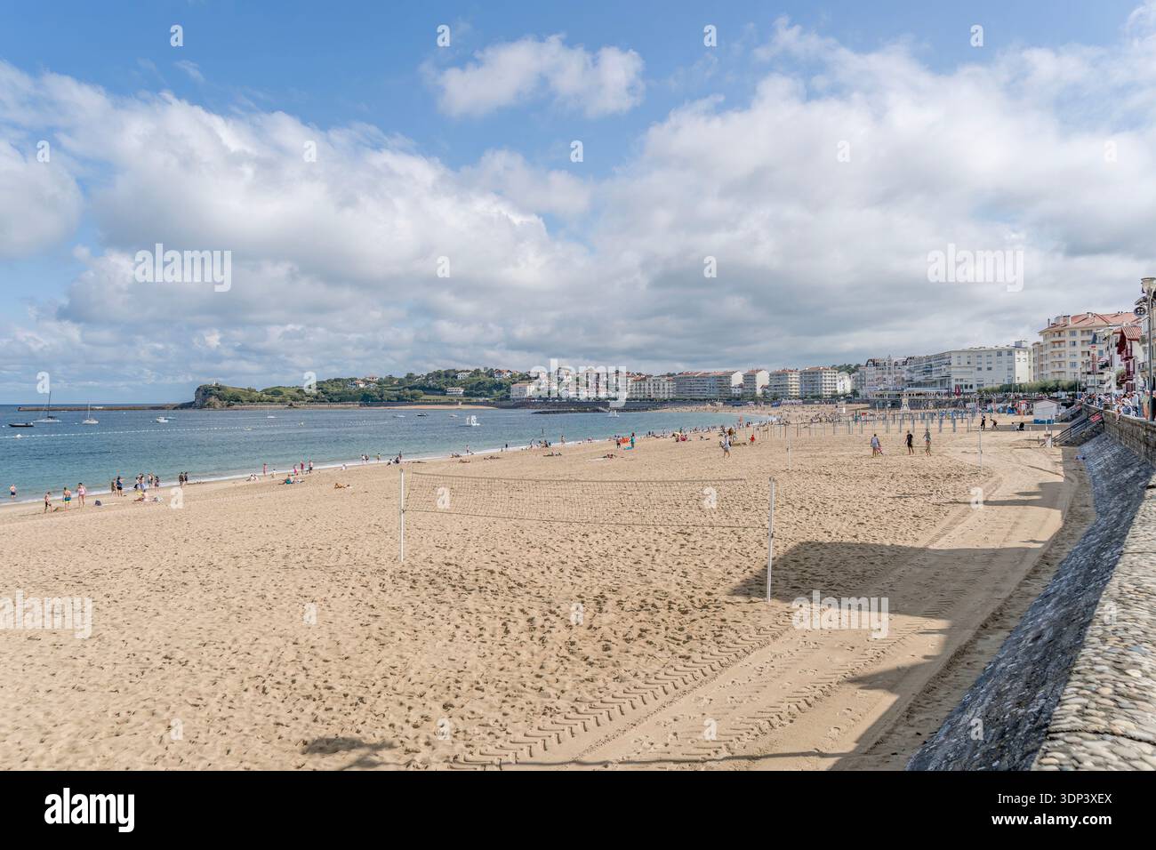 Saint Jean de Luz plage et baie avec des gens sous ciel nuageux, France, paysage urbain côtier Banque D'Images