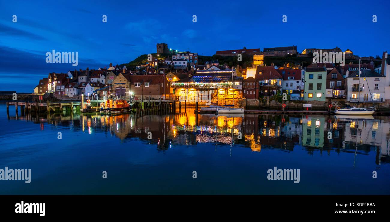Vue nocturne vers la rive est de la rivière Esk et Sandgate, avec East Cliff au-dessus, dans la ville balnéaire historique de Whitby dans le North Yorkshire, Angleterre, Royaume-Uni Banque D'Images