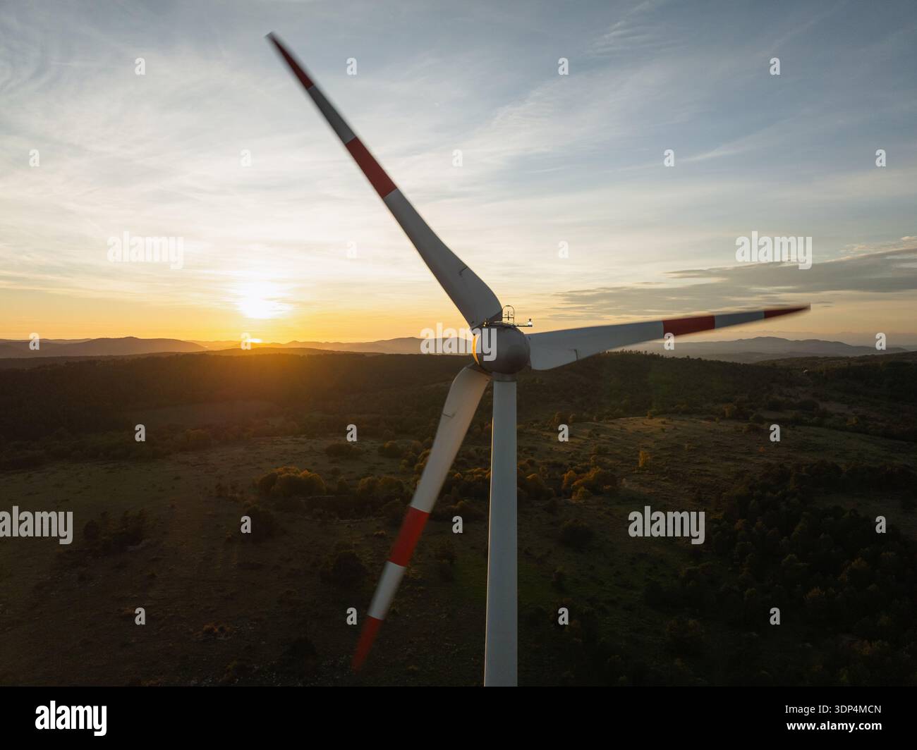 L'éolienne se tient haute contre un ciel dramatique pendant le coucher du soleil. Banque D'Images