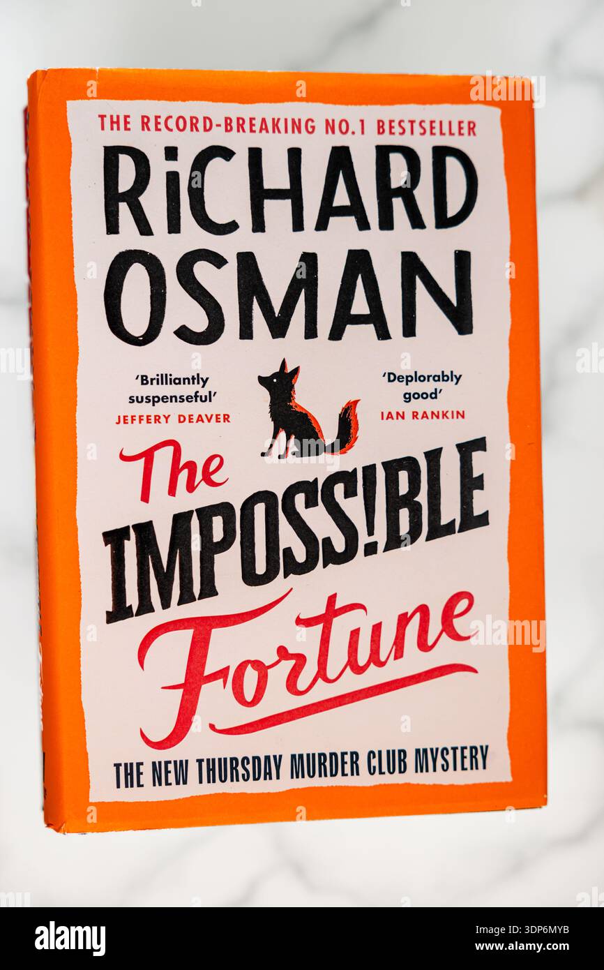 Une copie rigide du livre intitulé 'The impossible Fortune' de Richard Osman, avec une bordure orange frappante sur la couverture avec une illustration d'un renard Banque D'Images