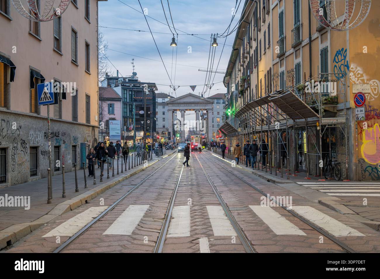 Voies de tramway menant à l'Arco della Pace à Milan, Italie, avec piétons et bâtiments résidentiels historiques dans un centre-ville européen dynamique. Banque D'Images