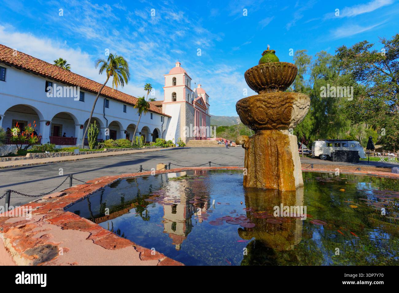 Historique Old Mission Santa Barbara, avec sa façade rose emblématique et ses clochers jumeaux, se reflète dans les eaux tranquilles d'une fontaine en pierre sous un Banque D'Images