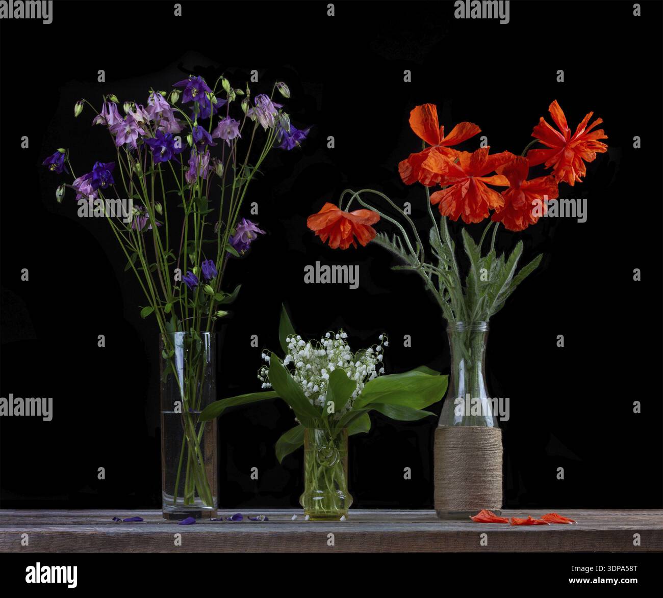Bouquet de coquelicots rouges, un bouquet de lys blancs de la vallée et un bouquet de fleurs cloches dans des vases en verre sur un fond noir gros plan Banque D'Images