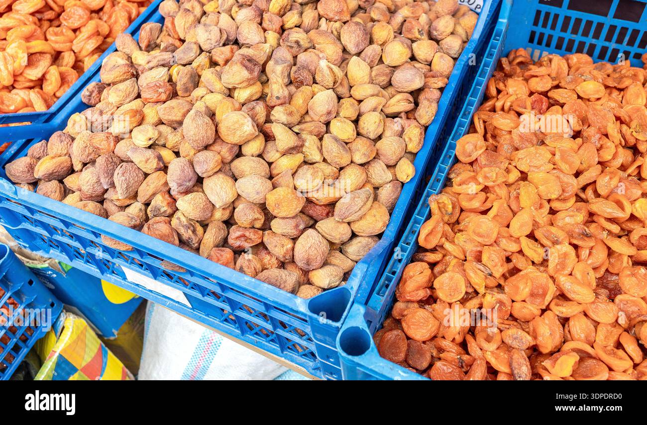 Abricots secs ouzbeks biologiques dans des caisses en plastique sur un marché fermier local. Grande pile d'abricots séchés, fruits secs, dessert sain, nourriture végétarienne Banque D'Images
