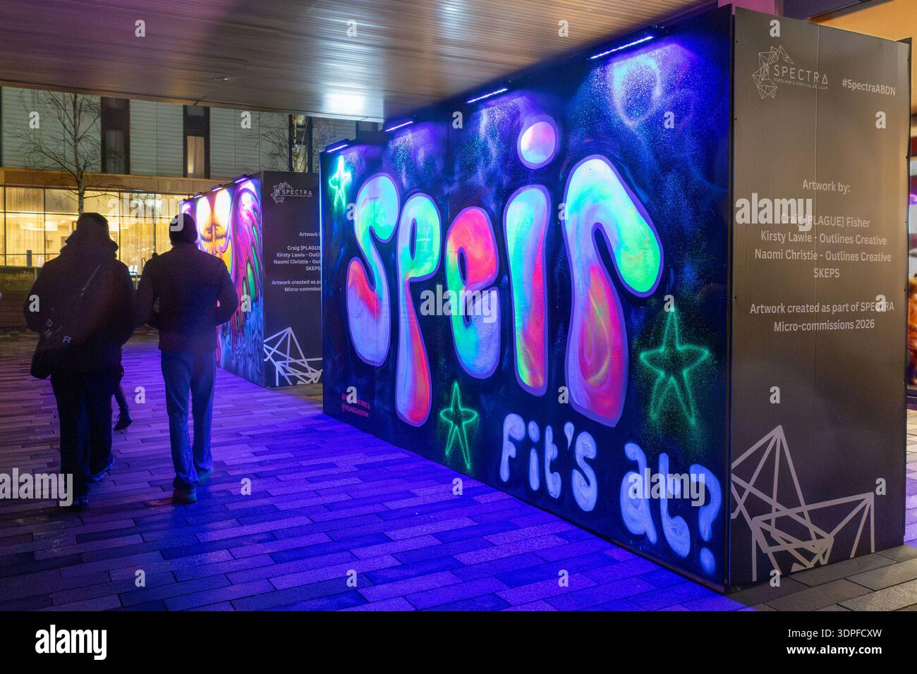 Les gens passent devant « Spier FIT's at ? » (Demandez ce qui se passe ?) Une microcommision pour le Spectra Festival of Light 2026, à Aberdeen, en Écosse. Banque D'Images