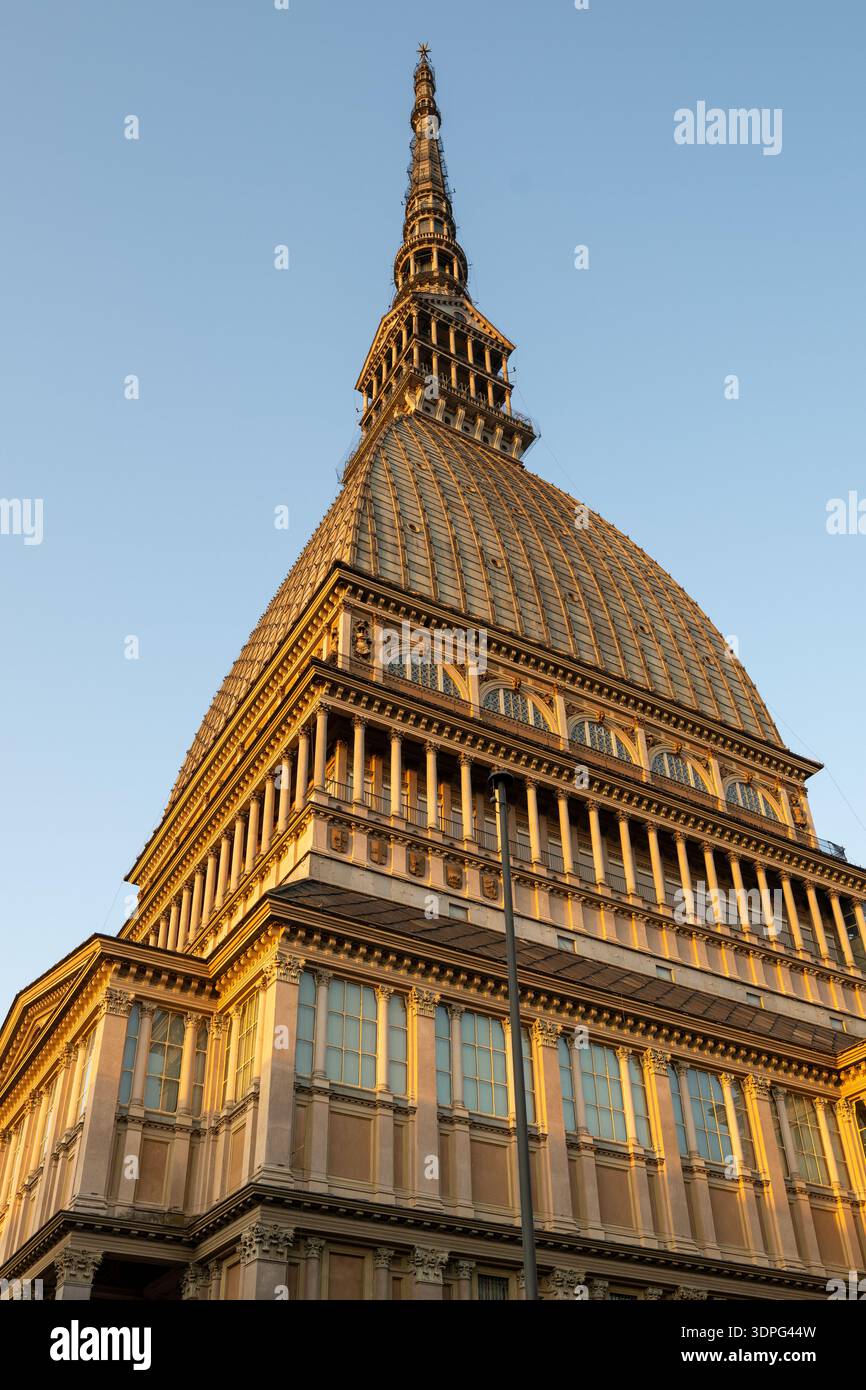 Vue en bas angle de mole Antonelliana à Turin au coucher du soleil, mettant en évidence le dôme en maçonnerie éclectique du XIXe siècle et la flèche montante. Banque D'Images