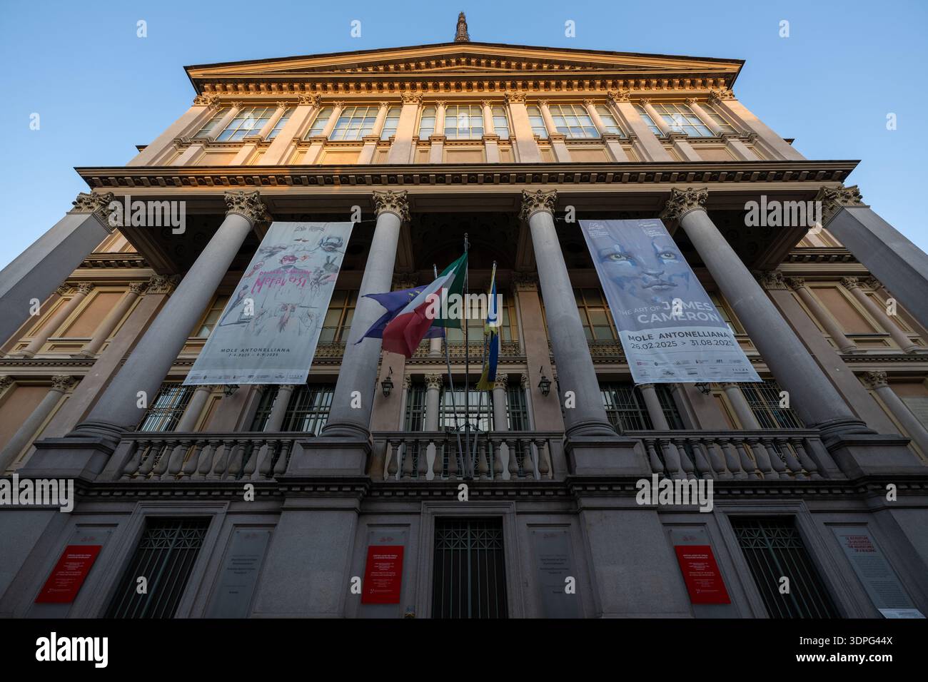 Turin, Italie - 9 août 2025 : vue en angle bas de la façade néoclassique mole Antonelliana à Turin, abritant le Musée National du Cinéma, avec drapeaux an Banque D'Images
