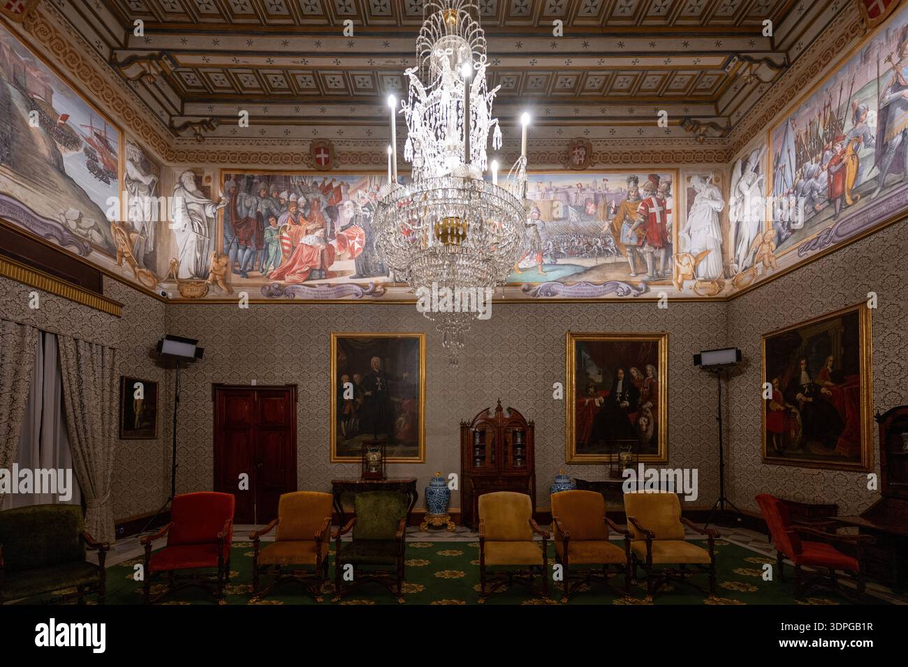 La Valette, Malte - 13 août 2025 : intérieur du palais des grands maîtres à la Valette avec lustre en cristal, frise décorée de fresques, plafond à caissons, portraits et Banque D'Images