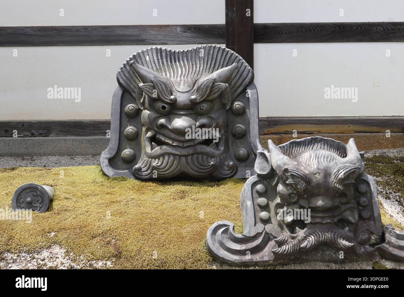 Tuiles de toit traditionnelles japonaises Onigawara Ogre-face dans un jardin de mousse zen Banque D'Images