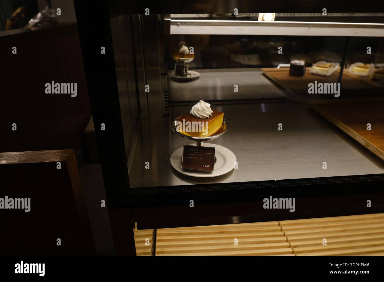 Une portion de pudding japonais à la crème fouettée dans une vitrine en verre dans un café de Komazawa Banque D'Images