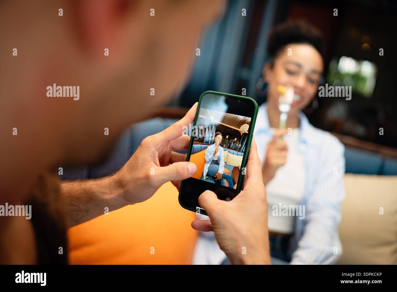 Un couple diversifié sur une date gourmande aime manger décontracté et un moment de téléphone, partageant des vibrations ensoleillées, des boissons Banque D'Images