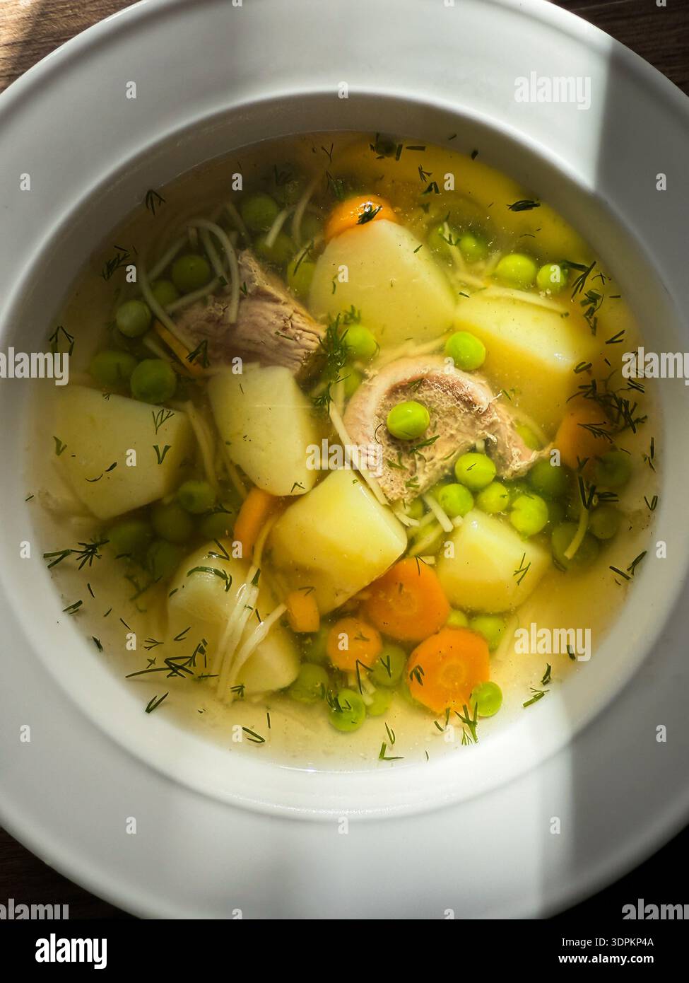 Bouillon clair soupe de poulet avec nouilles, pommes de terre, carottes, petits pois et aneth, offrir un repas réconfortant - Image de stock capturée avec un smartphone