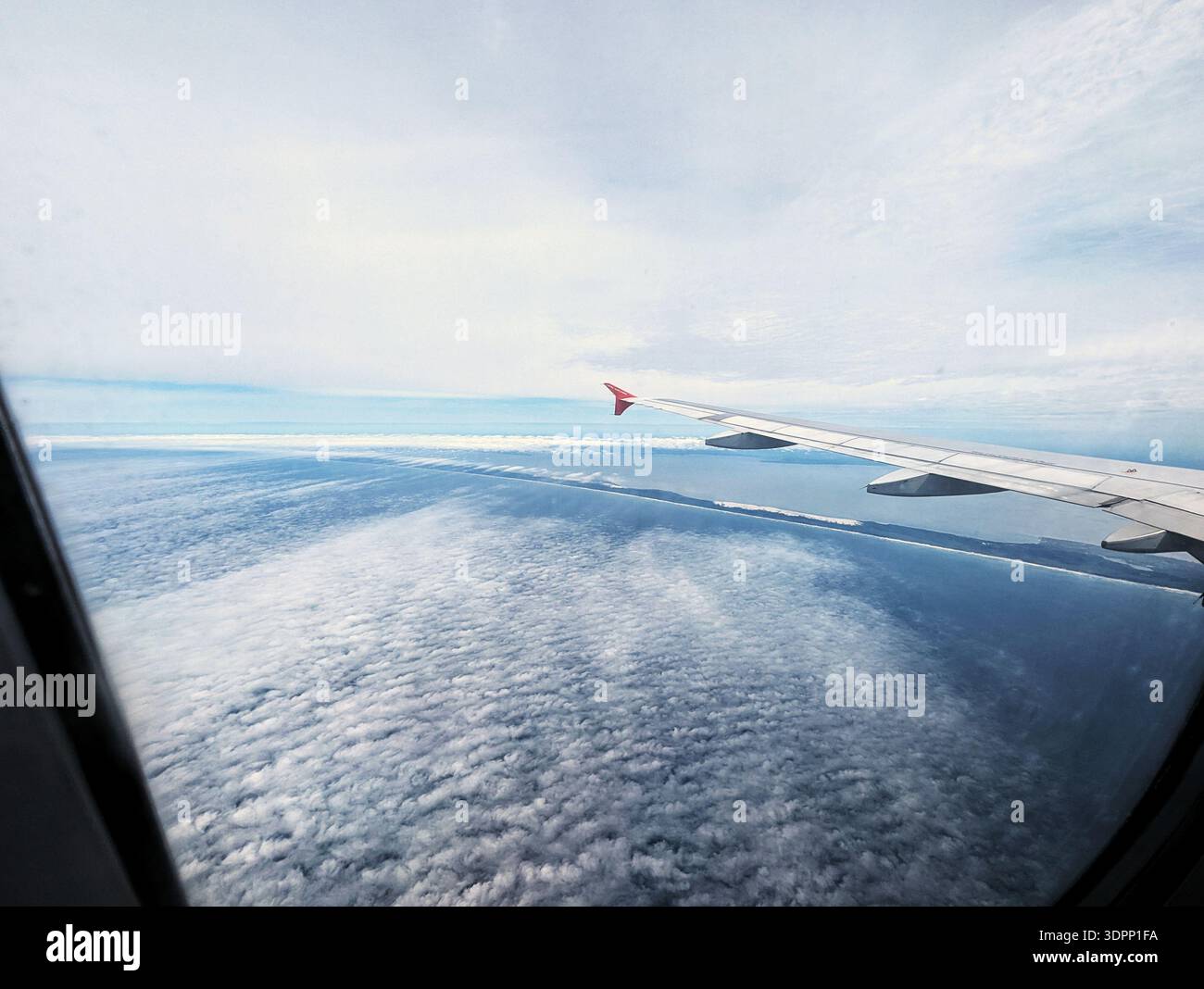 Aile d'avion observant des nuages océaniques tranquilles de haut en haut au-dessus de la lumière du matin. Point de vue surélevé capturant des paysages paisibles de mer et de ciel du Banque D'Images
