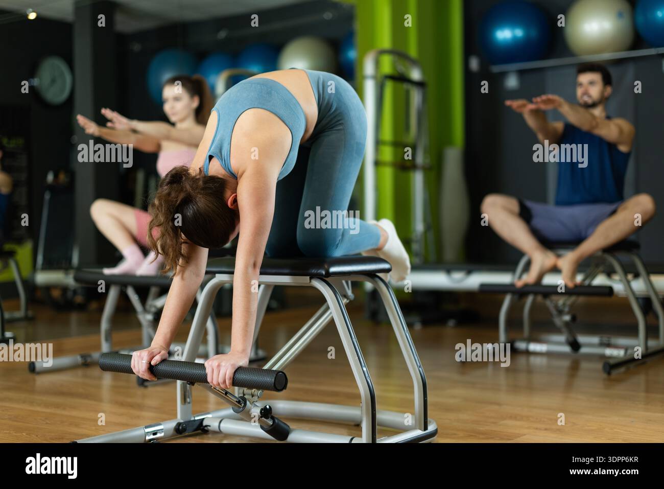 Jeune femme faisant des exercices pour les bras et la posture sur une chaise pilates Banque D'Images