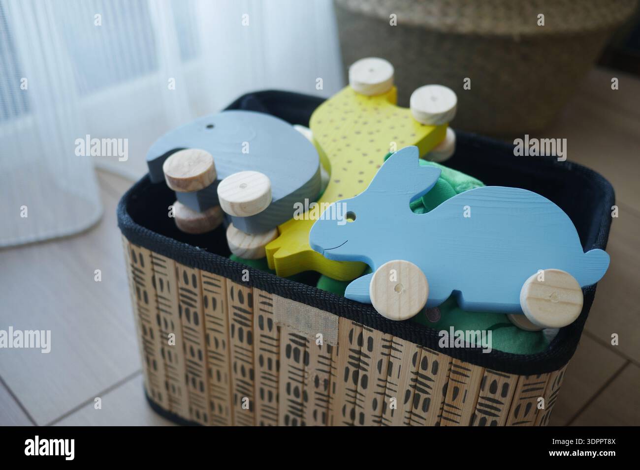 Jouets animaux en bois dans un panier dans la salle de jeux Banque D'Images
