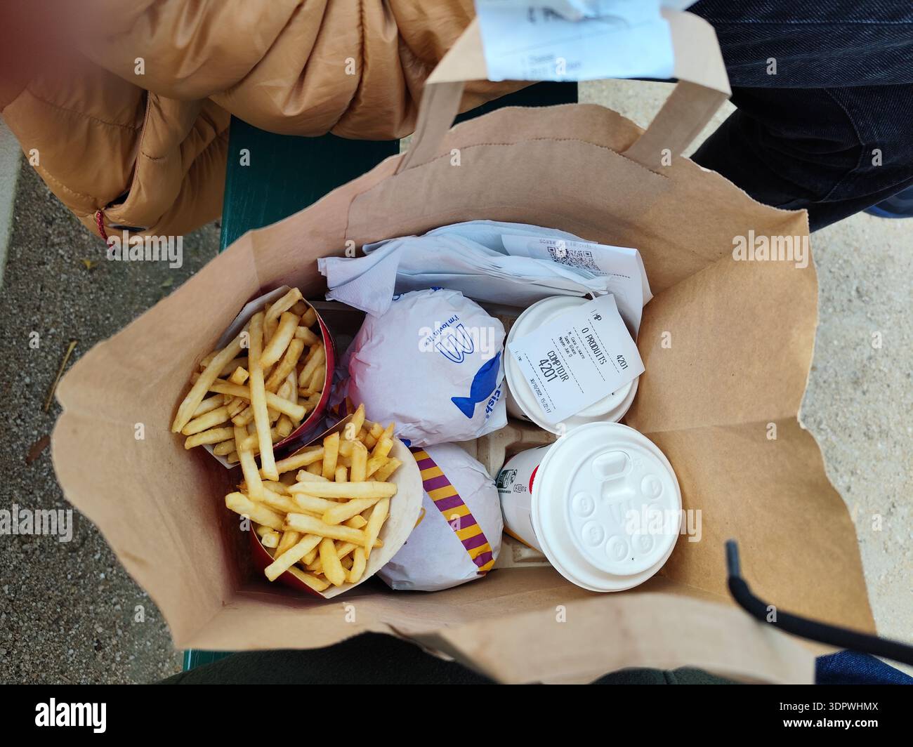 France, Paris - 29 octobre 2025 : Package Mc Menu McDonalds café. Hamburgers pommes de terre et boissons nourriture à emporter dans un sac en papier pour deux vues de dessus. Banque D'Images
