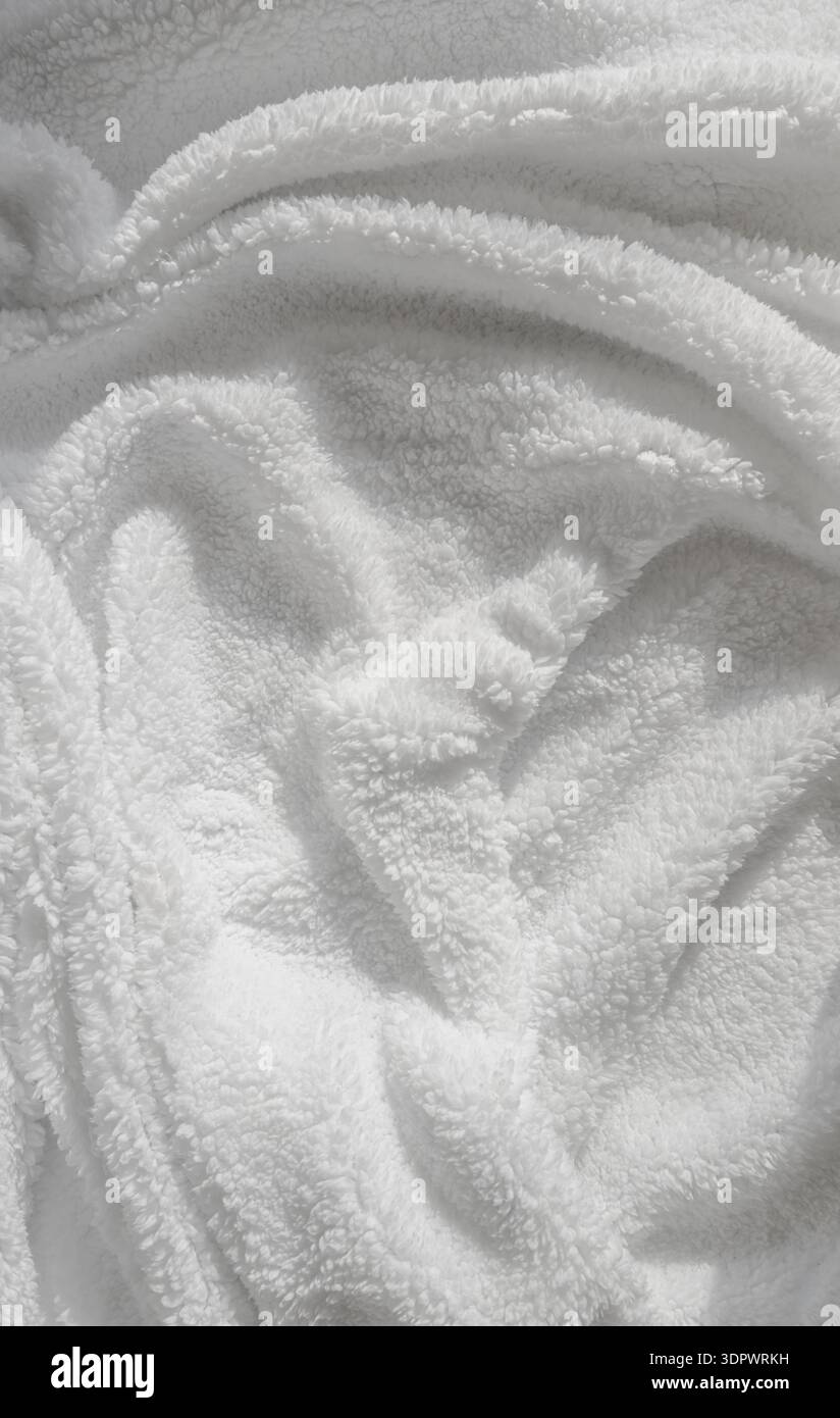 Gros plan de textile de fourrure synthétique blanc avec des fibres pelucheuses et une douceur lisse, créant une texture minimaliste propre adaptée à la mode ou au design. Banque D'Images