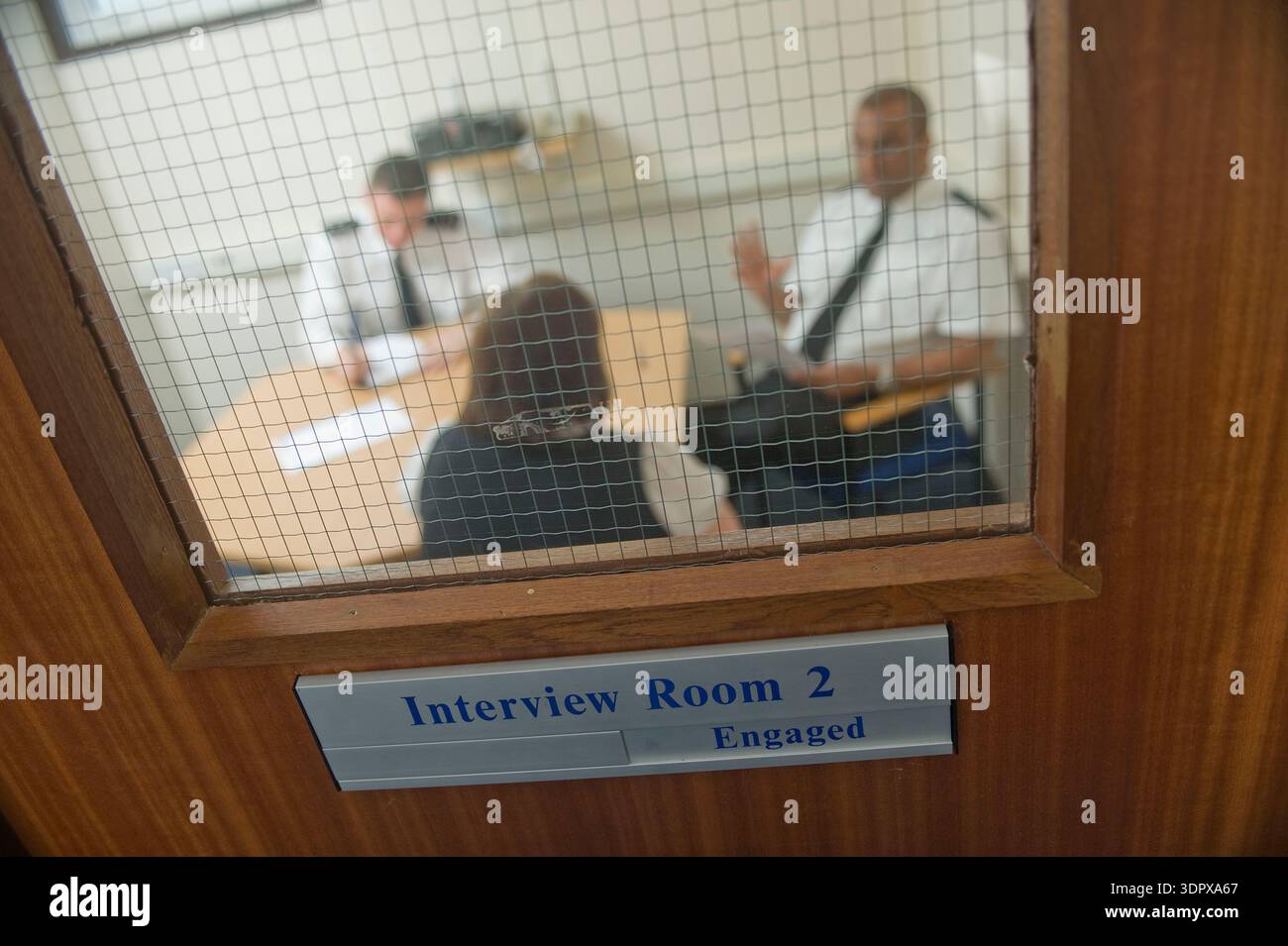 Policiers interrogeant un suspect - joué par un mannequin. Banque D'Images