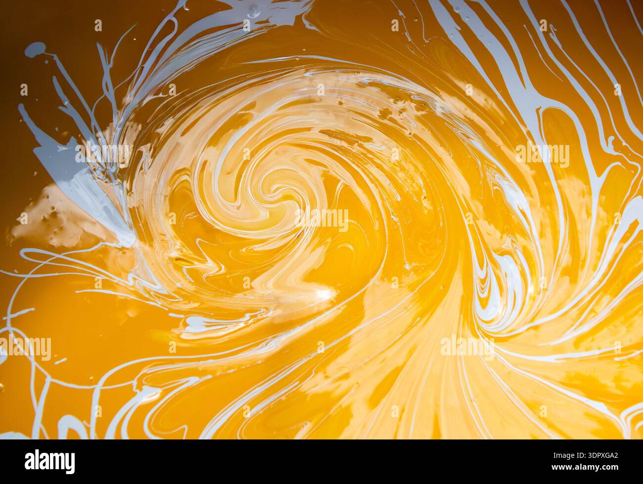 Peinture d'art fluide abstrait dans les peintures acryliques, peintures tourbillonnantes, couleurs jaune or et blanc créant Banque D'Images