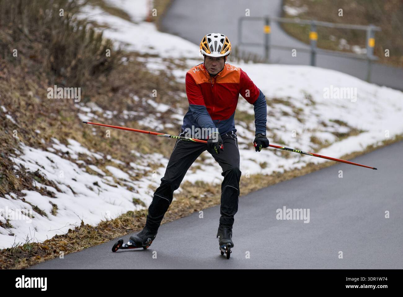 Ski à roulettes sur la piste cyclable en plein air, sport en hiver, glisse à roulettes sport dynamique, glisse sur un ski à roulettes au départ, bâtons de ski à roulettes SW Banque D'Images