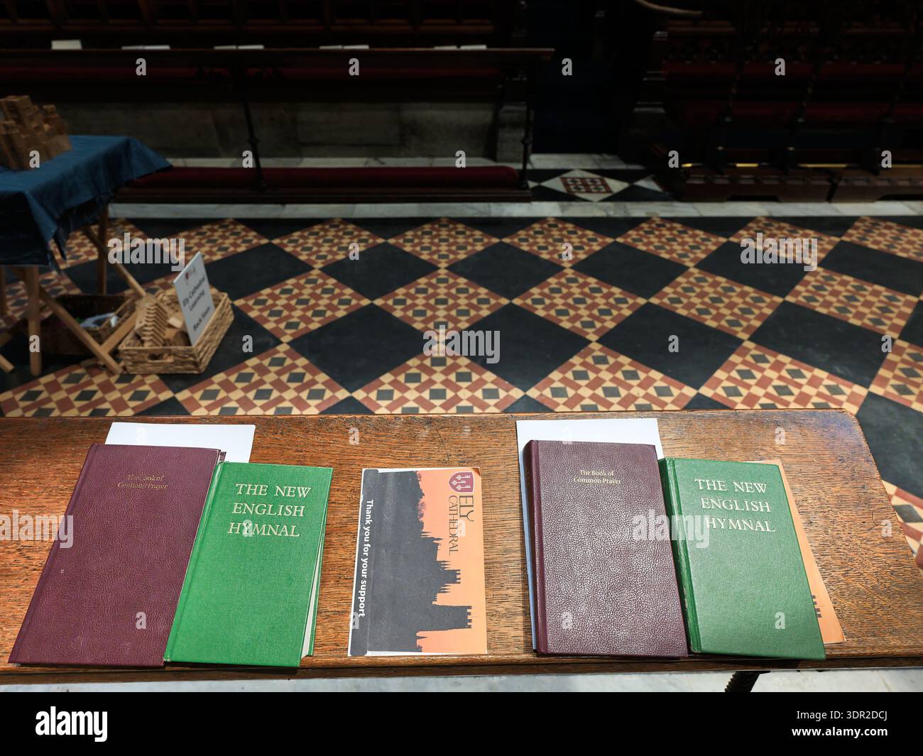 Hymnes et livres de prière sur un banc dans le chœur de la cathédrale chrétienne d'Ely, Angleterre. Banque D'Images