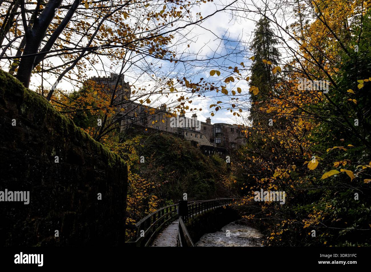 Vue en bas angle d'une passerelle en bois et d'une rivière qui coule rapidement en dessous du château de Skipton Banque D'Images