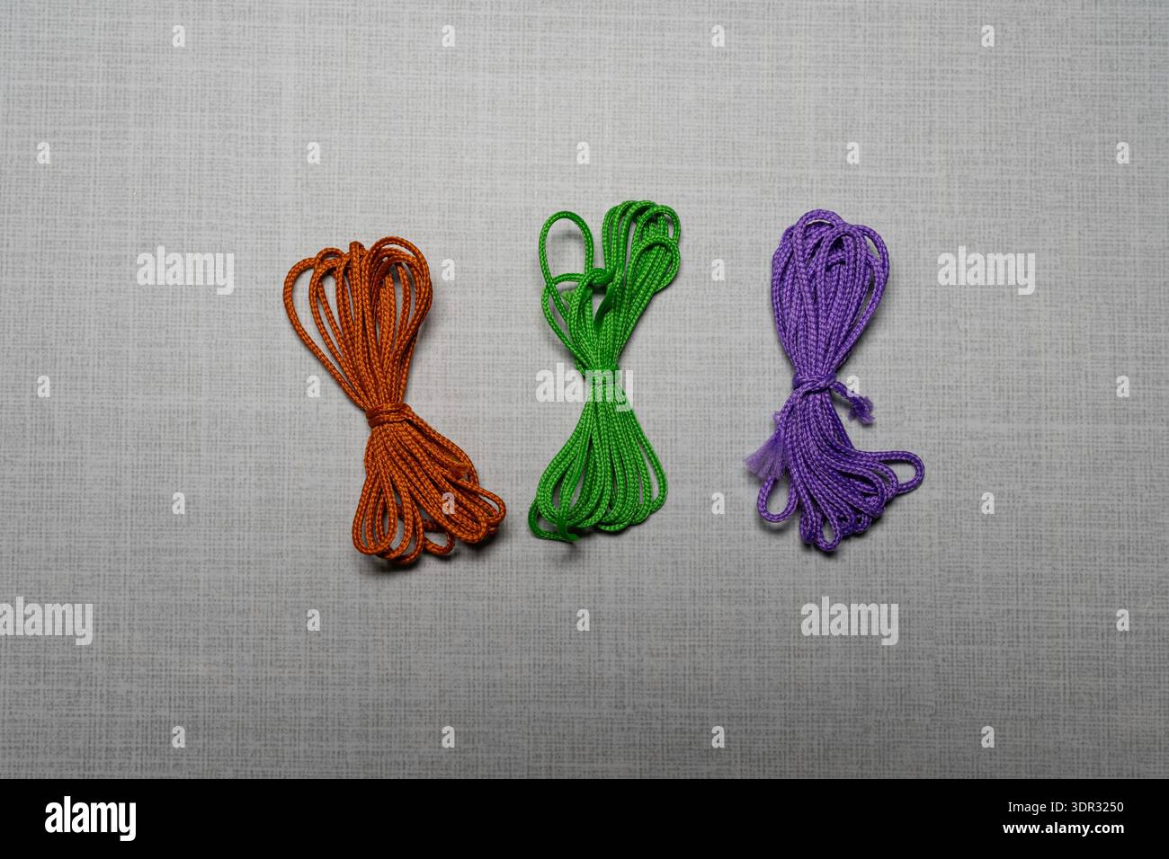 Faisceaux de cordons colorés assortis disposés dans la composition de pose plate, fournitures d'artisanat et concept de matériaux de bricolage, accessoires textiles pour macramé, couture, de Banque D'Images