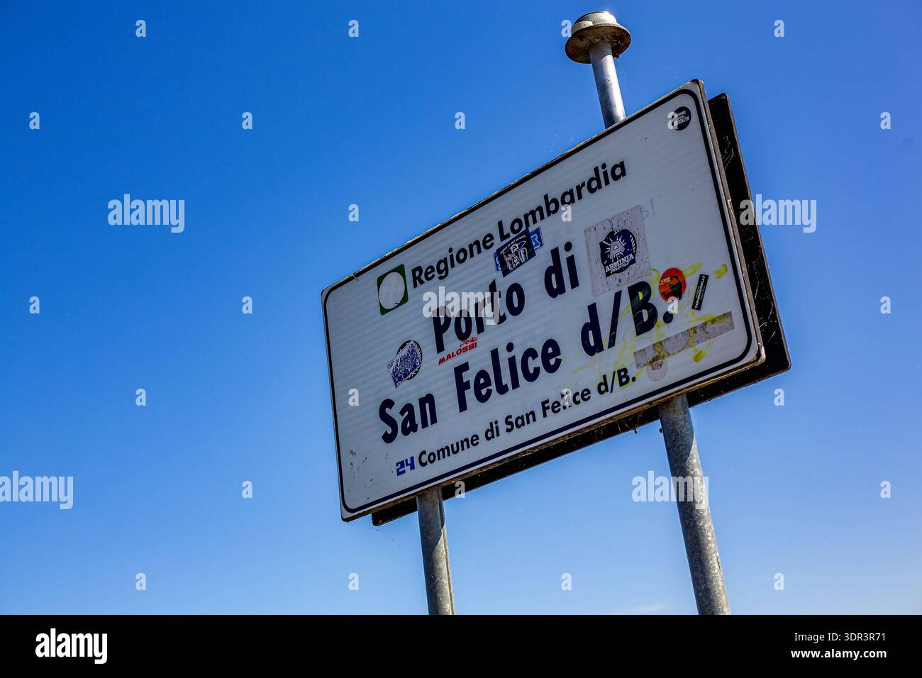 Schiffsanleger à Porto di San Felice am Gardasee. Der Porto di San Felice, gelegen im Ortsteil Spizzago von San Felice del Benaco am Westufer des Gardasees, ist ein Beliebter, Breiter Kiesstrand. Er bietet sauberes Wasser, schattenspendende Bäume, Liegestuhlverleih, Tretboote sowie eine Beach-Bar, Ideal für Familien und Erholungssuchende. Der Hafenbereich ist zudem Ausgangspunkt für Bootstouren. Porto di San Felice *** jetée à Porto di San Felice sur le lac de Garde le Porto di San Felice, situé dans le quartier Spizzago de San Felice del Benaco sur la rive ouest du lac de Garde, est un lieu populaire, Banque D'Images