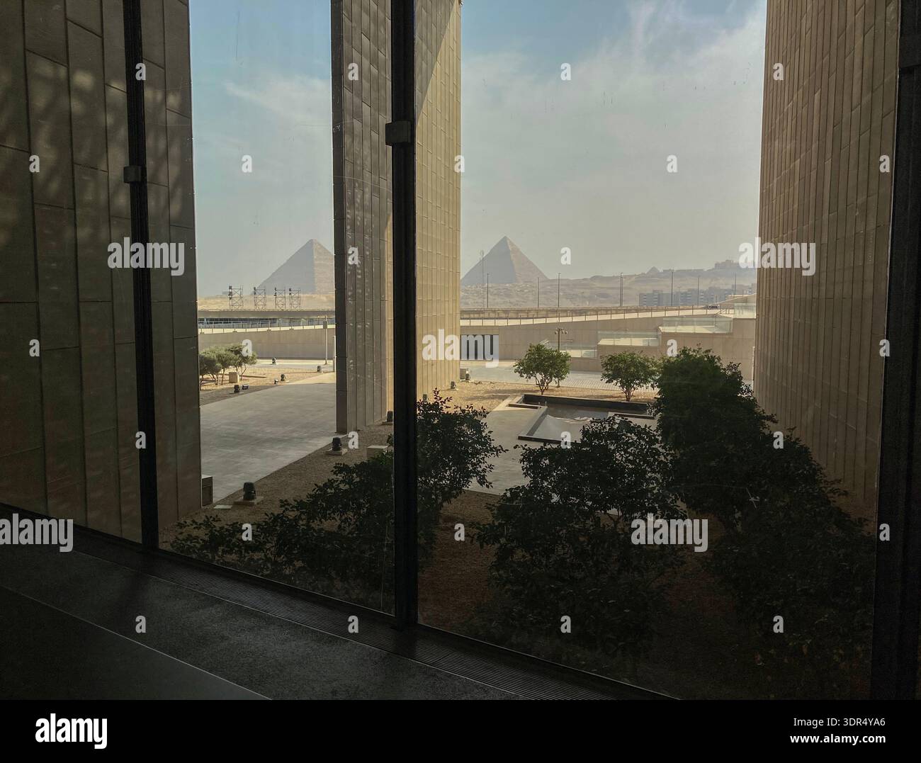 La vue s'étend sur près de 5 000 ans du Grand Musée égyptien du 21ème siècle après JC aux pyramides de Gizeh du 24ème siècle avant JC près du Caire, en Égypte. - Image de stock capturée avec un smartphone