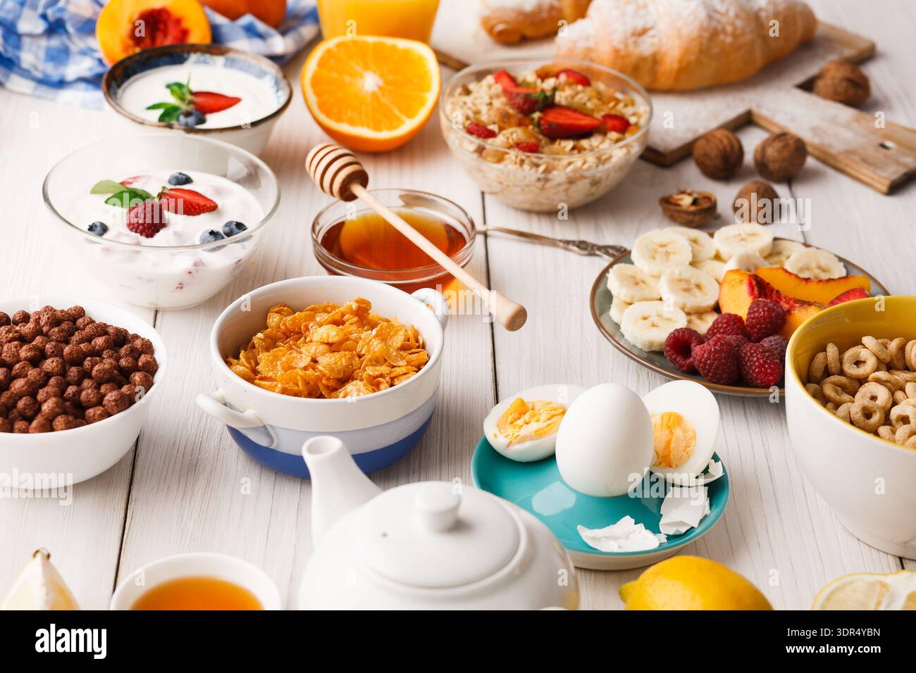 Petit déjeuner composé de fruits, céréales, yaourt et pain sur une table pendant le matin Banque D'Images