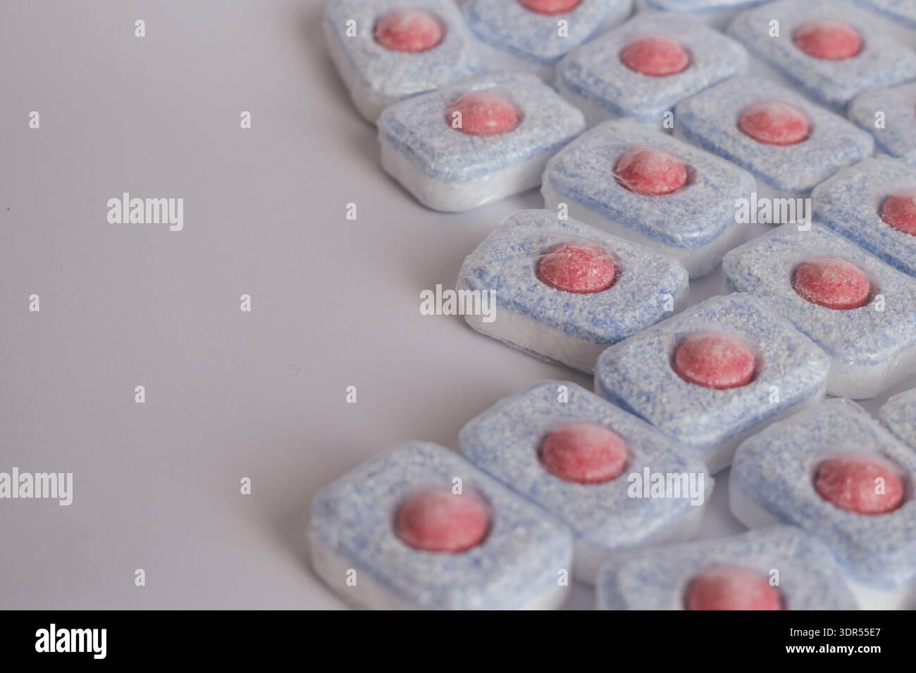 Design minimaliste : pastilles de nettoyage pour laver la vaisselle sur un fond blanc pur Banque D'Images