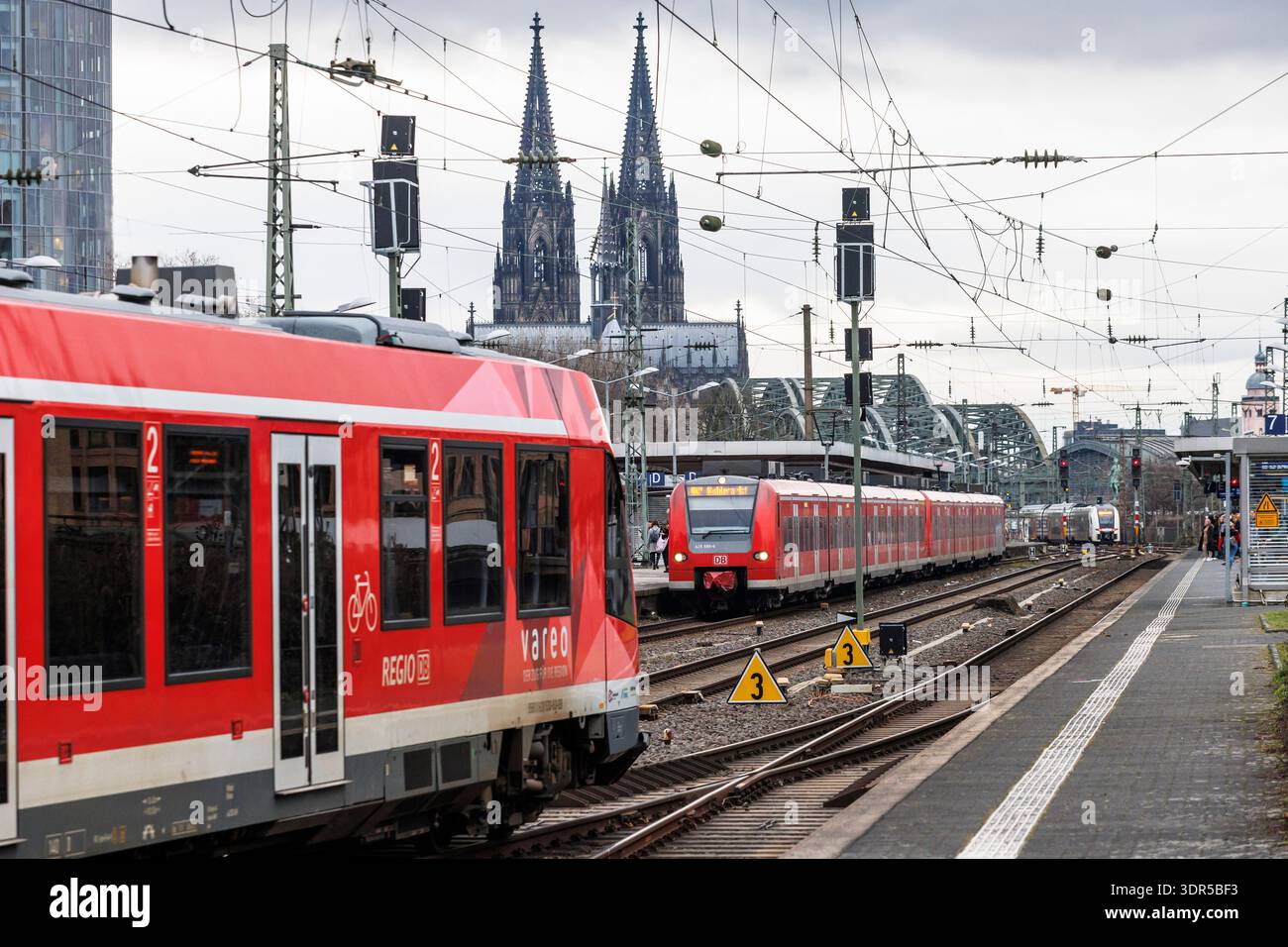 Trains locaux à la gare Messe-Deutz, en arrière-plan la cathédrale, Cologne, Allemagne. Nahverkehrszuege im Bahnhof Messe-Deutz, im Hintergrund der Do Banque D'Images