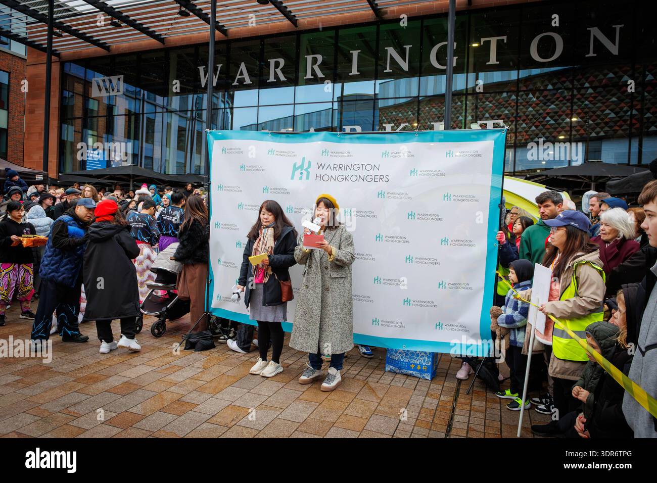 Célébrations du nouvel an lunaire 2026 à Time Square de Warrington pour accueillir l'année du cheval. Les Hongkongers de Warrington organisent un spectacle avec Dragon Dancing, stands traditionnels proposant des objets d'art et d'artisanat, jouets et cadeaux chinois, et nourriture de rue. Les jeux classiques du carnaval de Hong Kong étaient disponibles parallèlement à des expériences culturelles telles que FAI Chun, l'écriture de calligraphie chinoise et le discours de fortune. Les dames chinoises ouvrent l'événement avec des microphones à l'extérieur du marché intérieur de Warrington. Crédit : John Hopkins/Alamy Live News Banque D'Images