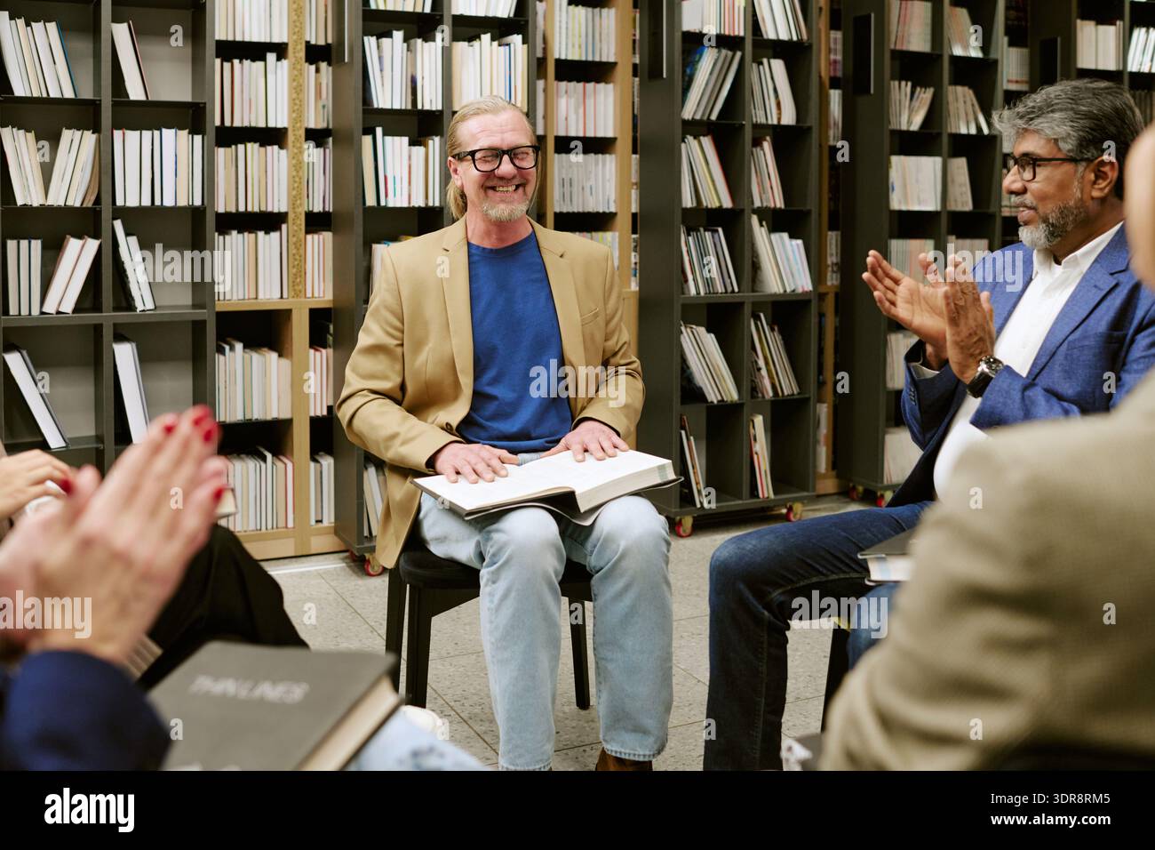 Présentation d'un homme caucasien d'âge moyen au cours d'un groupe de discussion sur le livre Banque D'Images